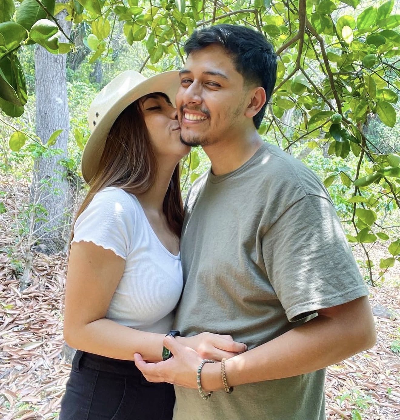Alejandra besando a Axel en un bosque